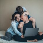 Family enjoying time together while working on a laptop at home.